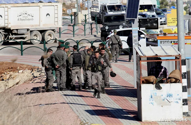Israeli forces stand near the scene where Israeli paramilitary police officers shot and killed a Palestinian who Israeli police said ran toward them brandishing a knife, near the Israeli Tapouh junction south of the West...