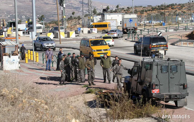 Israeli forces stand near the scene where Israeli paramilitary police officers shot and killed a Palestinian who Israeli police said ran toward them brandishing a knife, near the Israeli Tapouh junction south of the West...