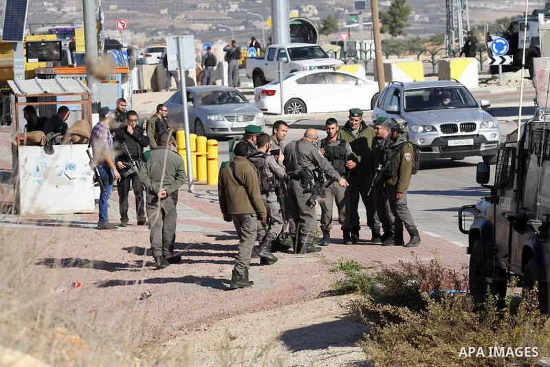 Israeli forces stand near the scene where Israeli paramilitary police officers shot and killed a Palestinian who Israeli police said ran toward them brandishing a knife, near the Israeli Tapouh junction south of the West...
