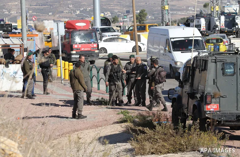 Israeli forces stand near the scene where Israeli paramilitary police officers shot and killed a Palestinian who Israeli police said ran toward them brandishing a knife, near the Israeli Tapouh junction south of the West...