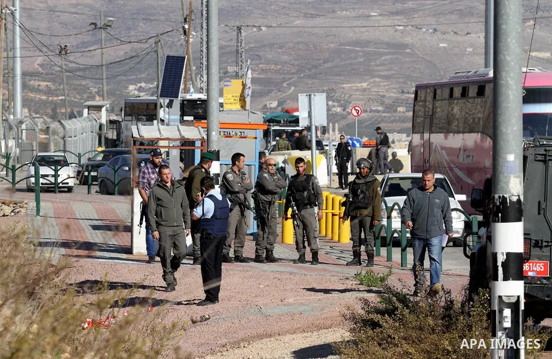 Israeli forces stand near the scene where Israeli paramilitary police officers shot and killed a Palestinian who Israeli police said ran toward them brandishing a knife, near the Israeli Tapouh junction south of the West...
