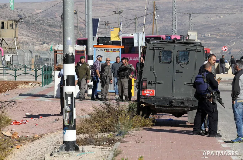 Israeli forces stand near the scene where Israeli paramilitary police officers shot and killed a Palestinian who Israeli police said ran toward them brandishing a knife, near the Israeli Tapouh junction south of the West...