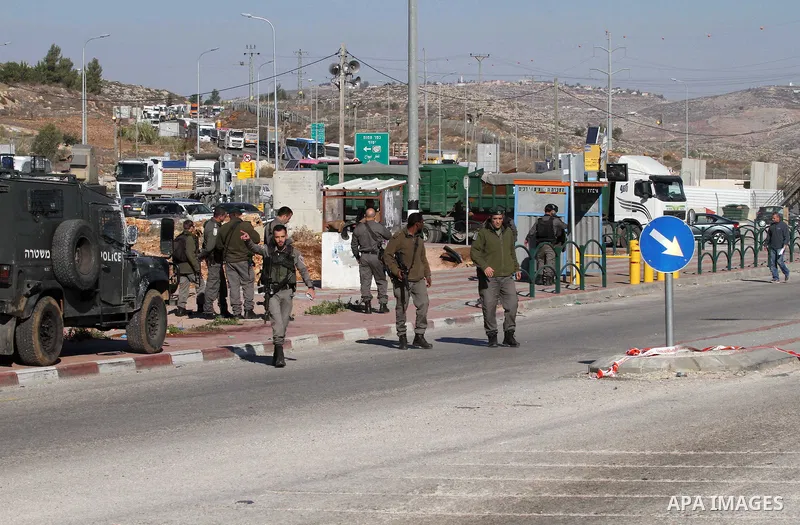 Israeli forces stand near the scene where Israeli paramilitary police officers shot and killed a Palestinian who Israeli police said ran toward them brandishing a knife, near the Israeli Tapouh junction south of the West...