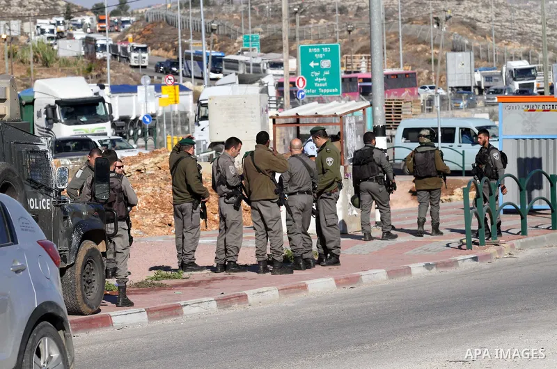 Israeli forces stand near the scene where Israeli paramilitary police officers shot and killed a Palestinian who Israeli police said ran toward them brandishing a knife, near the Israeli Tapouh junction south of the West...