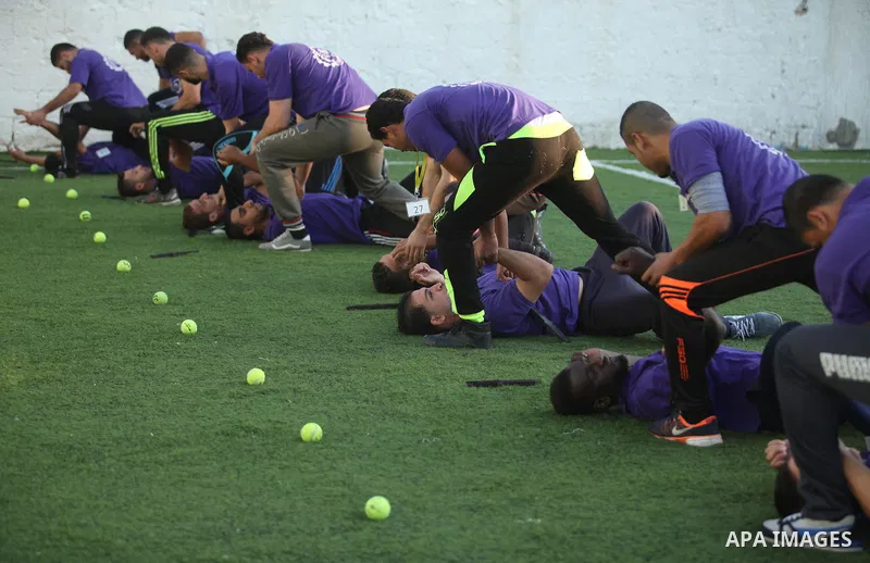 Palestinian applicants for a private security guard job at Castle Security company undergo a physical examination in an open-air playground in Gaza City on December 08, 2016. Photo by Ashraf Amra