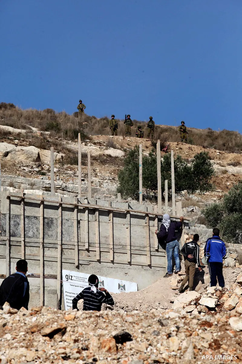 Palestinian protesters hurl stones towards Israeli security forces during clashes following a demonstration against the expropriation of Palestinian land by Israel in the village of Kfar Qaddum, near Nablus, in the occup...