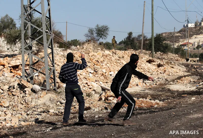 Palestinian protesters hurl stones towards Israeli security forces during clashes following a demonstration against the expropriation of Palestinian land by Israel in the village of Kfar Qaddum, near Nablus, in the occup...