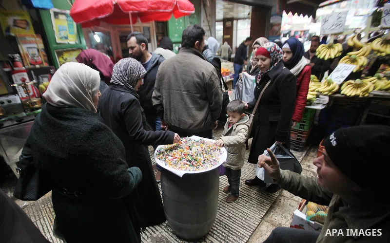 Palestinians eat candy during a ritual ceremony to commemorate the birth of the Prophet Mohammed, known in Arabic as "al-Mawlid al-Nabawi", in the West Bank city of Nablus on December 11, 2016. Photo by Nedal Eshtayah