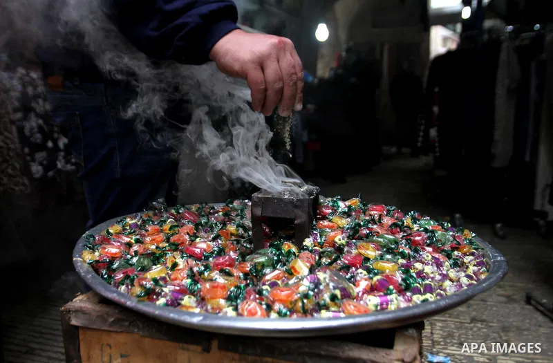 Palestinians eat candy during a ritual ceremony to commemorate the birth of the Prophet Mohammed, known in Arabic as "al-Mawlid al-Nabawi", in the West Bank city of Nablus on December 11, 2016. Photo by Nedal Eshtayah