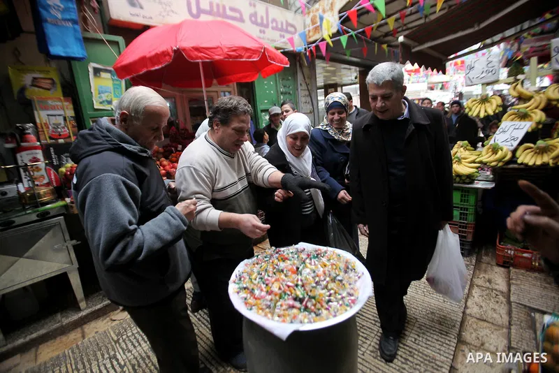 Palestinians eat candy during a ritual ceremony to commemorate the birth of the Prophet Mohammed, known in Arabic as "al-Mawlid al-Nabawi", in the West Bank city of Nablus on December 11, 2016. Photo by Nedal Eshtayah