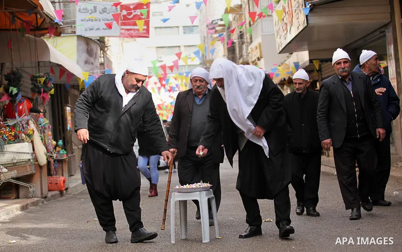 Palestinians eat candy during a ritual ceremony to commemorate the birth of the Prophet Mohammed, known in Arabic as "al-Mawlid al-Nabawi", in the West Bank city of Nablus on December 11, 2016. Photo by Nedal Eshtayah