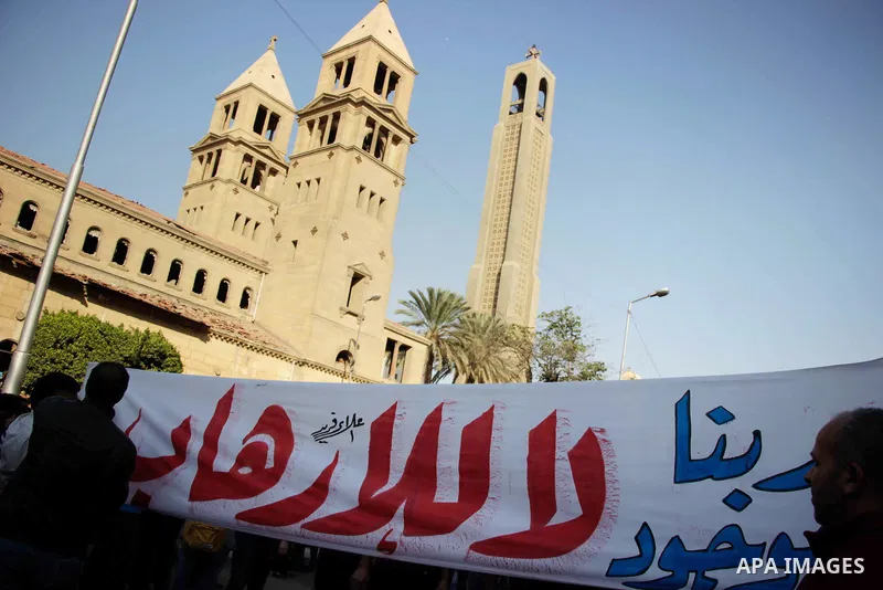 Egyptian Christians chant anti-terrorism slogans outside the the Saint Peter and Saint Paul Coptic Orthodox Church in Cairo's Abbasiya neighbourhood after it was targeted by a bomb explosion on December 11, 2016, . The b...