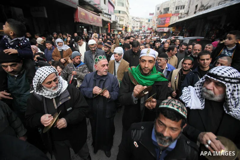 Palestinians Muslim Sufis play musical instruments as they parade through the streets during a ceremony commemorating the birth of Prophet Mohammed, known in Arabic as "Mawlid al-Nabawi", in the West Bank city of Nablus...