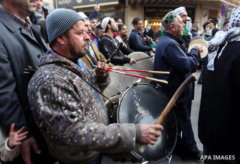 Palestinians Muslim Sufis play musical instruments as they parade through the streets during a ceremony commemorating the birth of Prophet Mohammed, known in Arabic as "Mawlid al-Nabawi", in the West Bank city of Nablus...