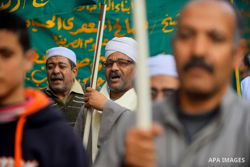 Egyptian Sufi Muslims chant prayers while walking in a march with banners as they celebrate "Mawlid al-Nabawi" or the birth of Prophet Mohammad, in old Cairo, Egypt, on December 11, 2016. Photo by Amr Sayed