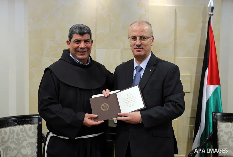 Palestinian Prime Minister Rami Hamdallah, receives an invitation to attend Midnight Mass for Christmas holiday, in the Wes bank city of Ramallah, on December 12, 2016. Photo by Prime Minister Office