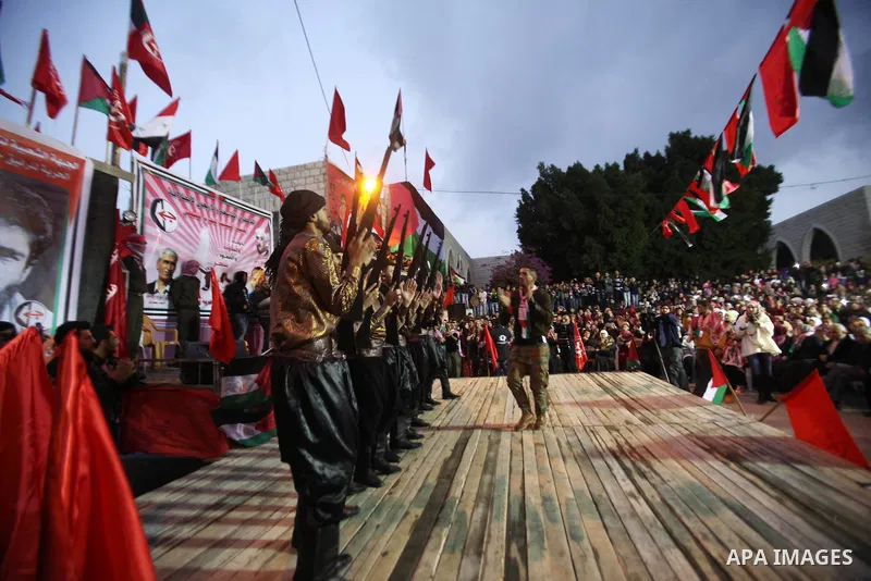 Palestinians take part in a rally marking the 49th anniversary of the founding of the Popular Front for the Liberation of Palestine (PFLP), in the village of Asira Shamaliya, north of the West Bank city of Nablus on 12 D...