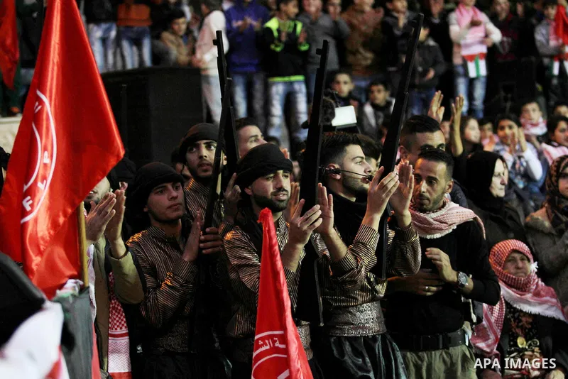 Palestinians take part in a rally marking the 49th anniversary of the founding of the Popular Front for the Liberation of Palestine (PFLP), in the village of Asira Shamaliya, north of the West Bank city of Nablus on 12 D...