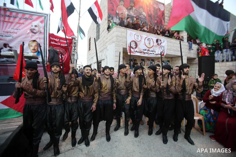 Palestinians take part in a rally marking the 49th anniversary of the founding of the Popular Front for the Liberation of Palestine (PFLP), in the village of Asira Shamaliya, north of the West Bank city of Nablus on 12 D...