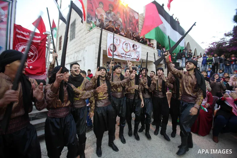 Palestinians take part in a rally marking the 49th anniversary of the founding of the Popular Front for the Liberation of Palestine (PFLP), in the village of Asira Shamaliya, north of the West Bank city of Nablus on 12 D...