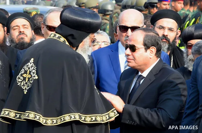 Egyptian President Abdel Fattah al-Sisi offers his condolences to Egypt's Coptic Pope Tawadros II in the end of the funeral of the victims of a bomb explosion that targeted a Coptic Orthodox Church in Cairo on December 1...