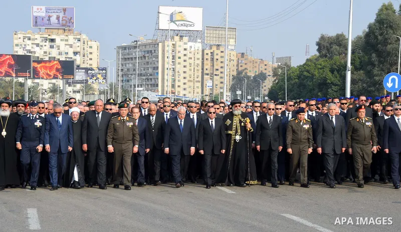 Egyptian President Abdel Fattah al-Sisi and Coptic Pope Tawadros walk alongside other officials during the funeral of the victims of a bomb explosion that targeted a Coptic Orthodox Church in Cairo, on December 12, 2016....