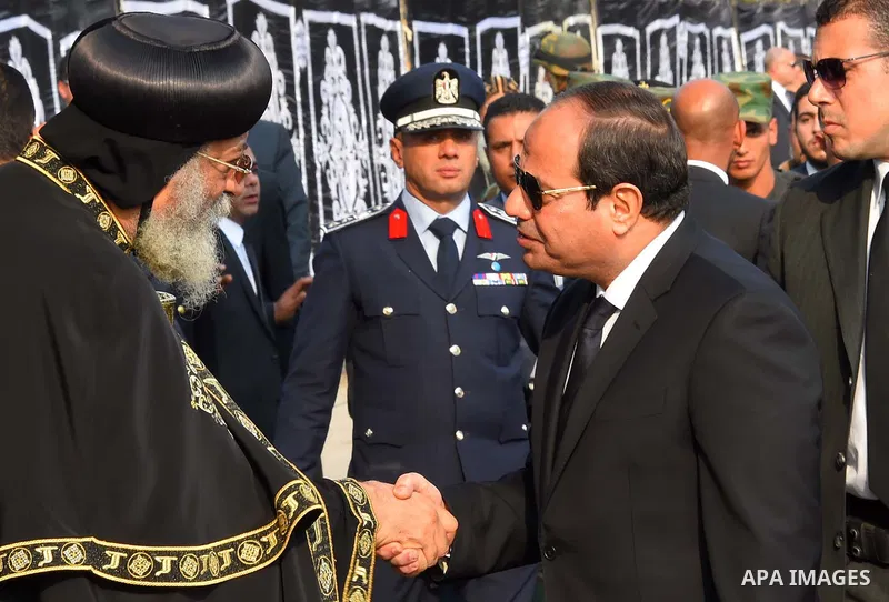 Egyptian President Abdel Fattah al-Sisi offers his condolences to Egypt's Coptic Pope Tawadros II in the end of the funeral of the victims of a bomb explosion that targeted a Coptic Orthodox Church in Cairo on December 1...