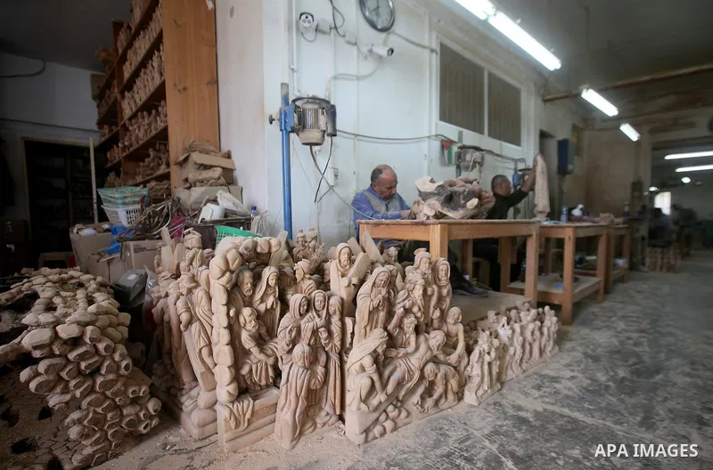 A Palestinian carpenter carves a wooden effigies of the the Holy Family at a workshop in the West Bank town of Bethlehem, on December 13, 2016. The traditional birthplace of Jesus Christ prepares to celebrate Christmas l...
