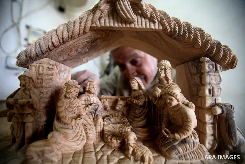 A Palestinian carpenter carves a wooden effigies of the the Holy Family at a workshop in the West Bank town of Bethlehem, on December 13, 2016. The traditional birthplace of Jesus Christ prepares to celebrate Christmas l...
