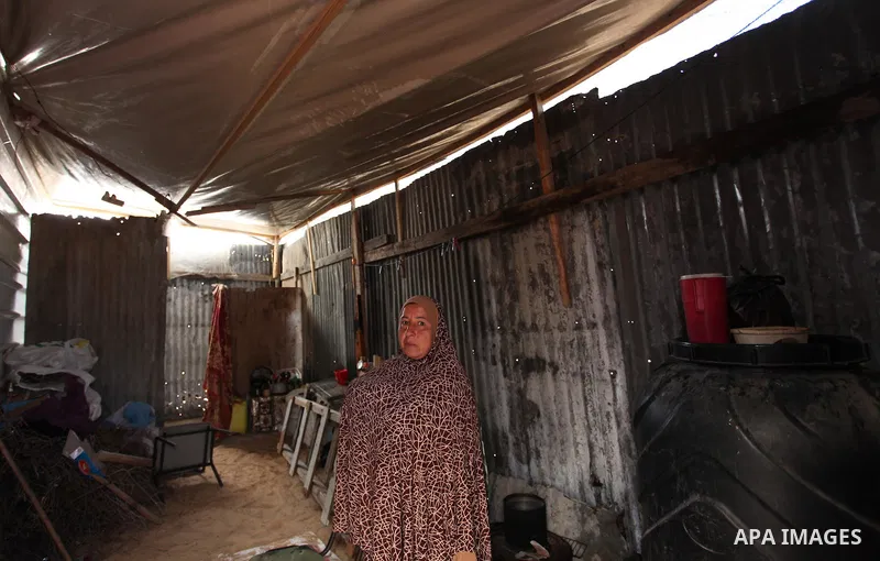 A Palestinian woman stands inside her dwelling during the winter storm in Khan Younis, in the southern Gaza Strip on December 14, 2016. Photo by Ashraf Amra