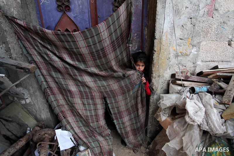 A Palestinian girl plays outside her family's shanty during the winter storm in Khan Younis, in the southern Gaza Strip on December 14, 2016. Photo by Ashraf Amra