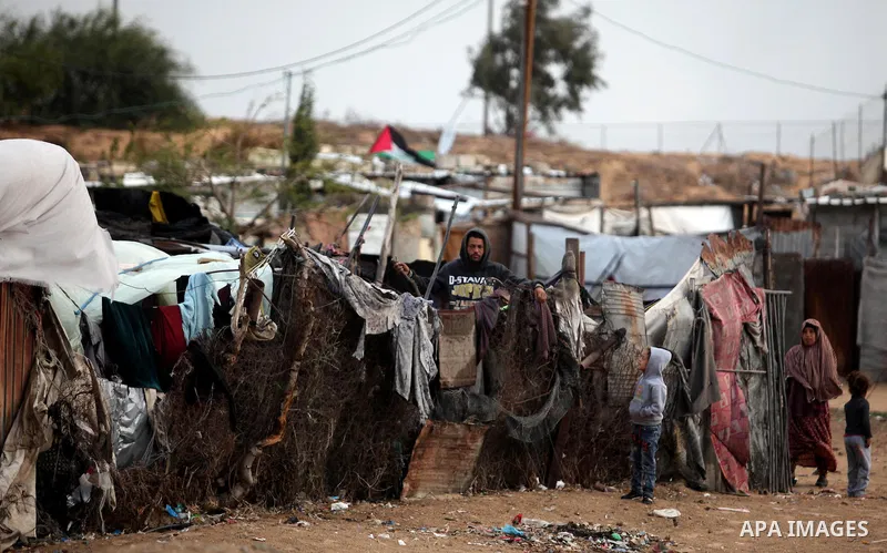 A Palestinian man looks out of his family's tent during the winter storm in Khan Younis, in the southern Gaza Strip on December 14, 2016. Photo by Ashraf Amra