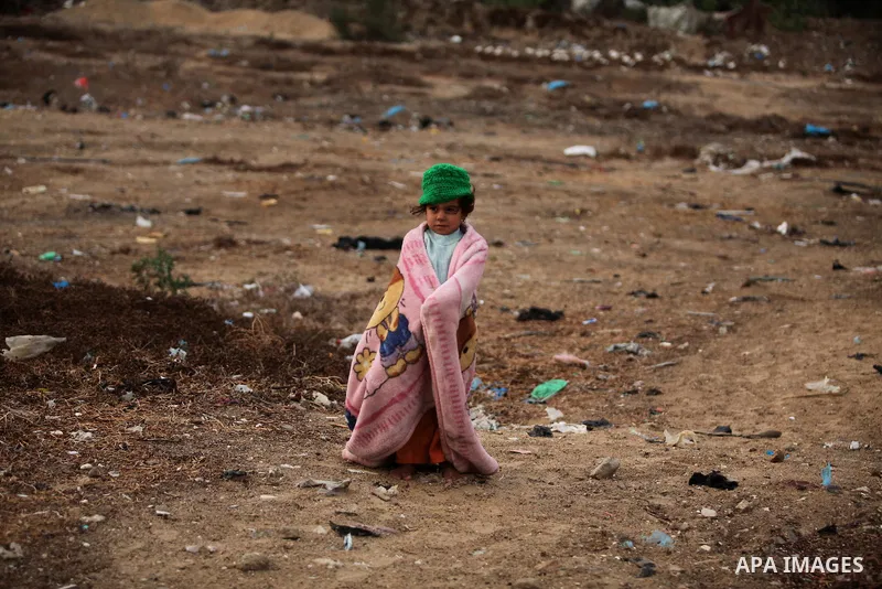A Palestinian girl plays outside her family's shanty during the winter storm in Khan Younis, in the southern Gaza Strip on December 14, 2016. Photo by Ashraf Amra
