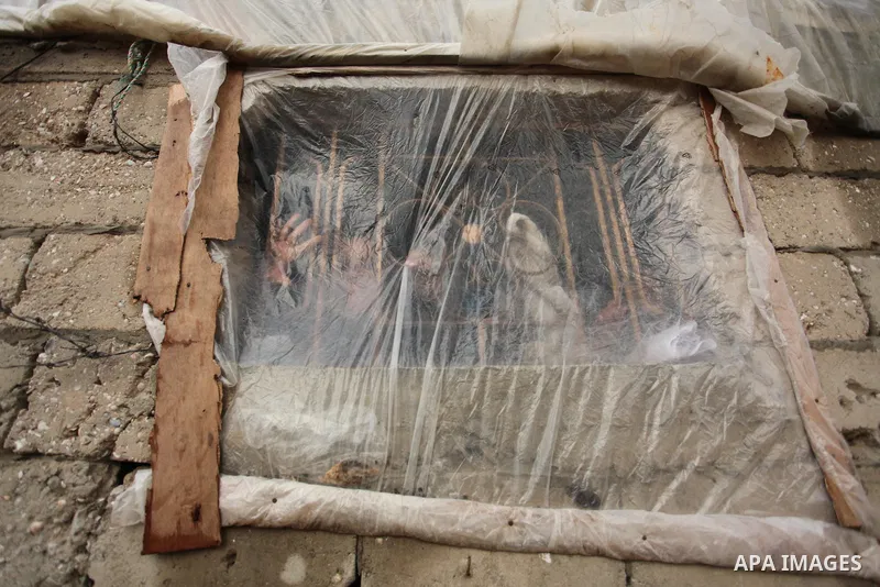A Palestinian boy looks through a Window of nylon during the winter storm in Khan Younis, in the southern Gaza Strip on December 14, 2016. Photo by Ashraf Amra