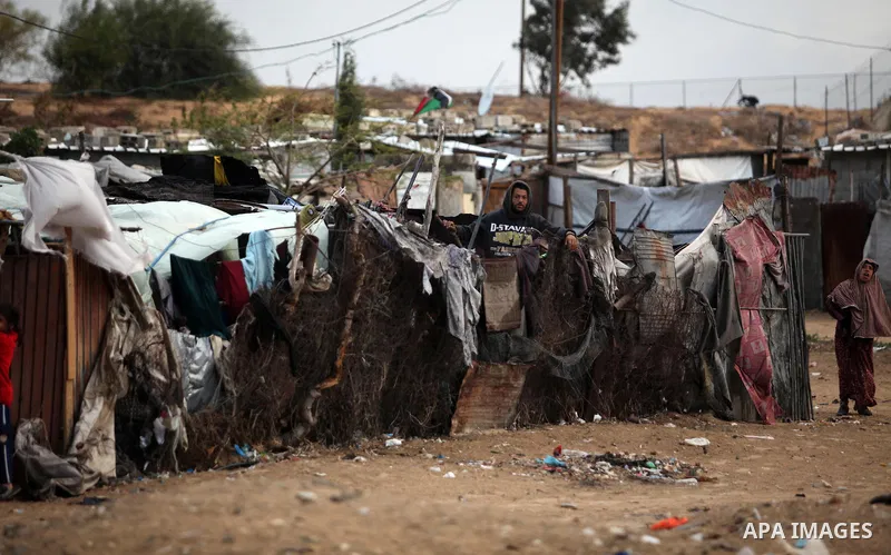 A Palestinian man looks out of his family's tent during the winter storm in Khan Younis, in the southern Gaza Strip on December 14, 2016. Photo by Ashraf Amra
