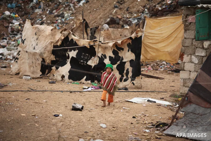 A Palestinian girl plays outside her family's shanty during the winter storm in Khan Younis, in the southern Gaza Strip on December 14, 2016. Photo by Ashraf Amra