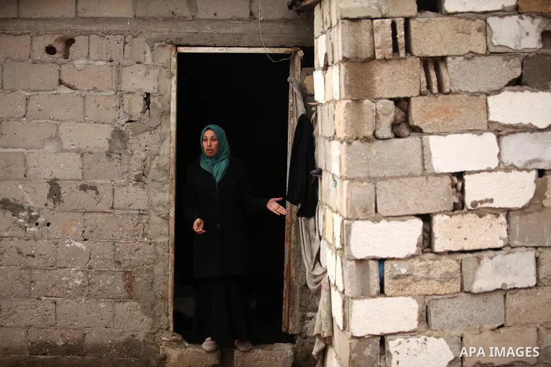 A Palestinian woman reacts outside her dwelling during the winter storm in Khan Younis, in the southern Gaza Strip on December 14, 2016. Photo by Ashraf Amra