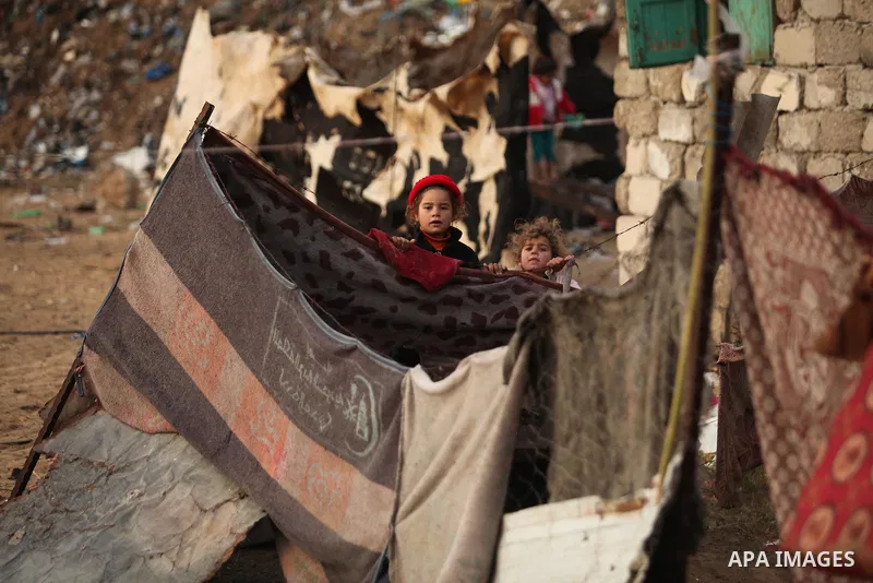 A Palestinian girl plays outside her family's shanty during the winter storm in Khan Younis, in the southern Gaza Strip on December 14, 2016. Photo by Ashraf Amra
