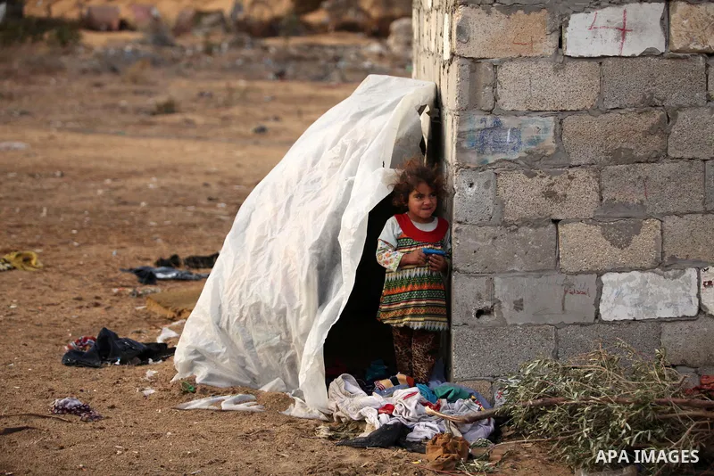 A Palestinian girl plays outside her family's shanty during the winter storm in Khan Younis, in the southern Gaza Strip on December 14, 2016. Photo by Ashraf Amra