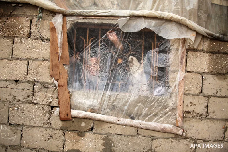 A Palestinian boy looks through a Window of nylon during the winter storm in Khan Younis, in the southern Gaza Strip on December 14, 2016. Photo by Ashraf Amra