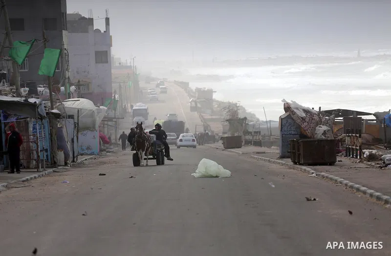 Palestininas walk at a street during a stormy day, in Gaza city on December 14, 2016. Photo by Mohammed Asad