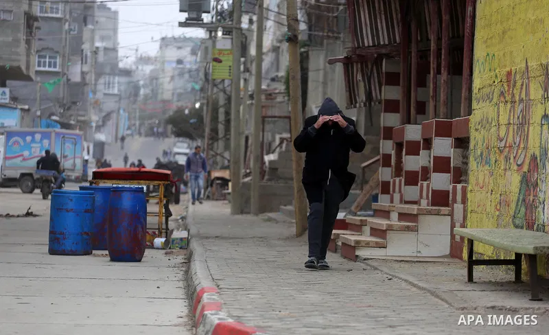 Palestininas walk at a street during a stormy day, in Gaza city on December 14, 2016. Photo by Mohammed Asad