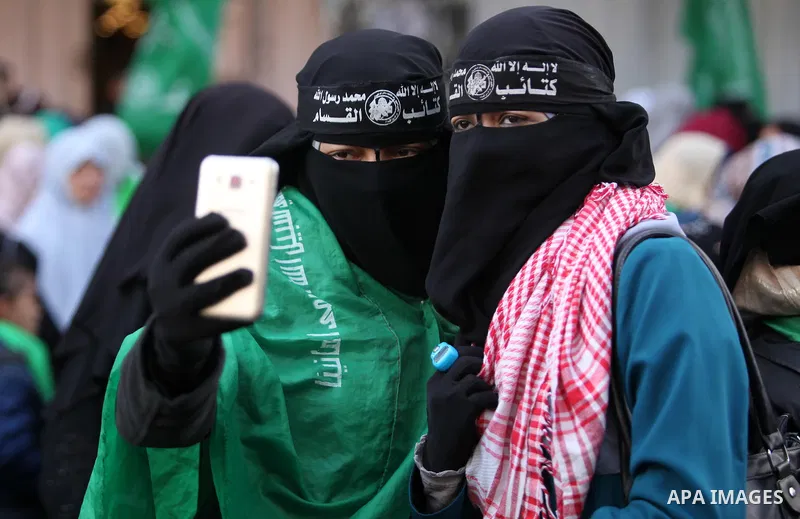 Palestinian girls take a selfie during a rally marking the 29th anniversary of the founding of the Hamas movement, in Gaza city December 14, 2016. Photo by Ashraf Amra