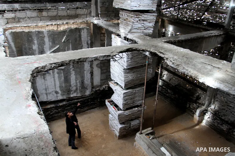 Dutch artist Marjan Teeuwen speaks with her assistant as she creates an architectural work that involves re-assembling wreckage of a house, that was destroyed during 2014, and turning it into artistic structures, in Khan...