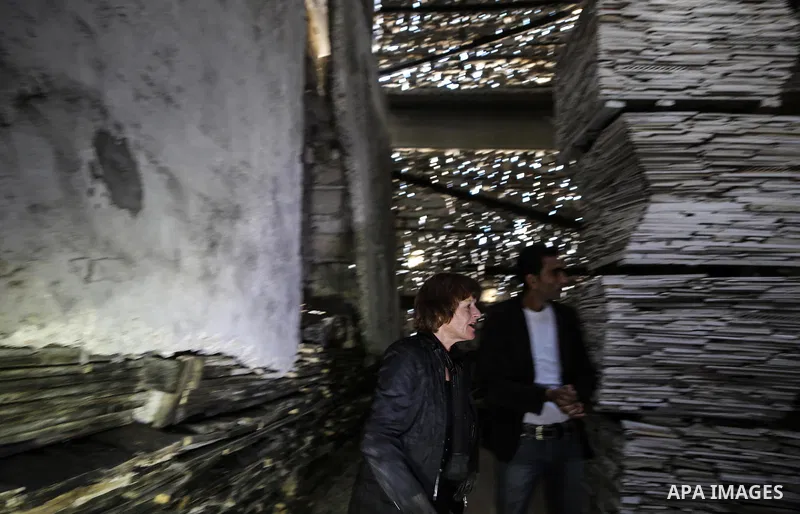 Dutch artist Marjan Teeuwen speaks with her assistant as she creates an architectural work that involves re-assembling wreckage of a house, that was destroyed during 2014, and turning it into artistic structures, in Khan...