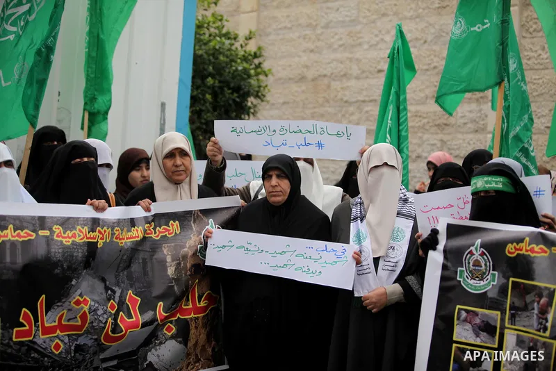 Palestinian children hold banners during a protest to solidarity with the inhabitants of the embattled Syrian city of Aleppo, in front of the high commissioner for human rights headquarters, in Gaza city, on December 15,...