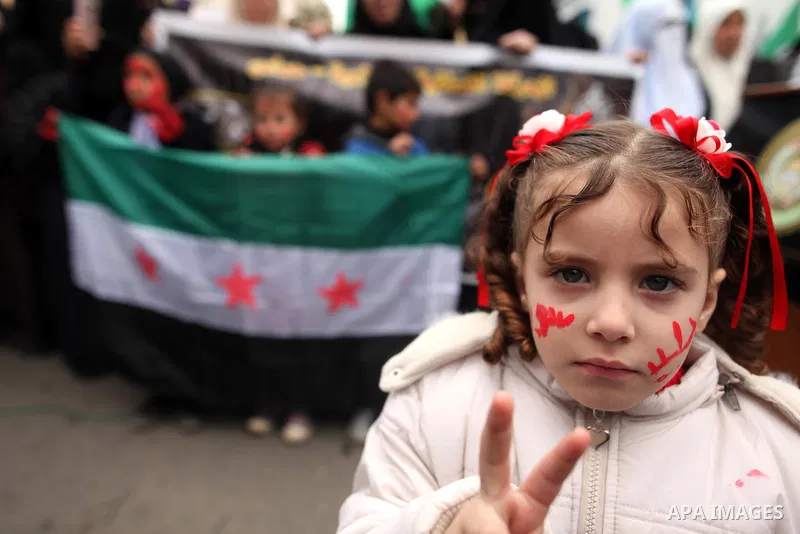 Palestinian children hold banners during a protest to solidarity with the inhabitants of the embattled Syrian city of Aleppo, in front of the high commissioner for human rights headquarters, in Gaza city, on December 15,...