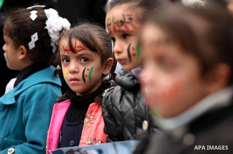 Palestinian children hold banners during a protest to solidarity with the inhabitants of the embattled Syrian city of Aleppo, in front of the high commissioner for human rights headquarters, in Gaza city, on December 15,...