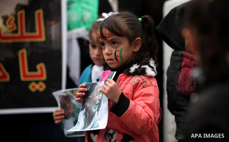 Palestinian children hold banners during a protest to solidarity with the inhabitants of the embattled Syrian city of Aleppo, in front of the high commissioner for human rights headquarters, in Gaza city, on December 15,...