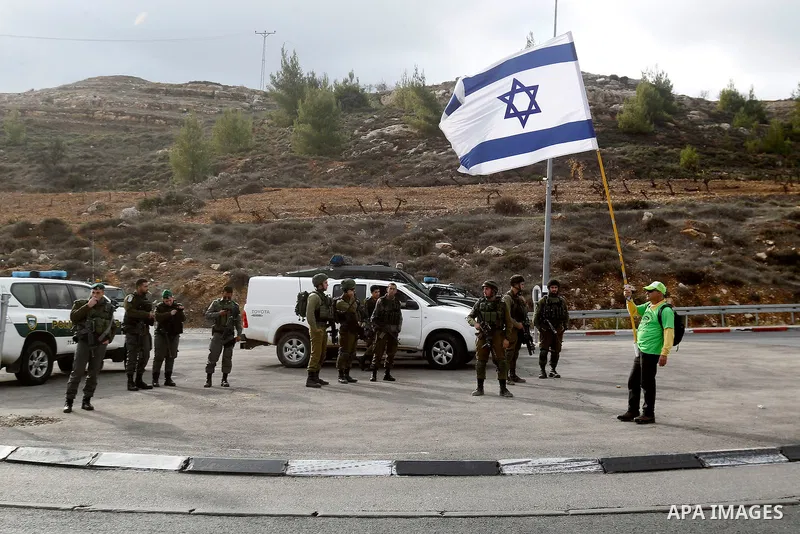 Peace activists hold placards during a joint Israeli-Palestinian peace march along the Israeli controversial separation wall in the West Bank city of Beit Jala between Bethlehem and Jerusalem, on December 16, 2016. Photo...